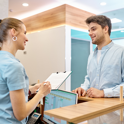 Man talking to young woman at front desk