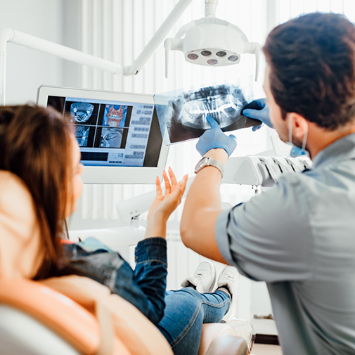 Orthodontist showing female patient an X ray