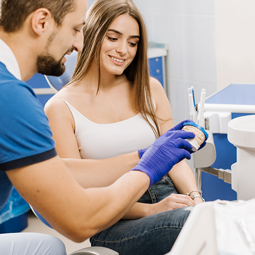 Orthodontist showing patient a model of teeth