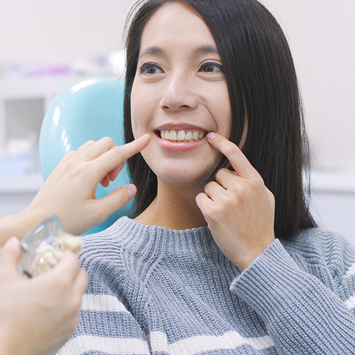 Female patient pointing to her smile