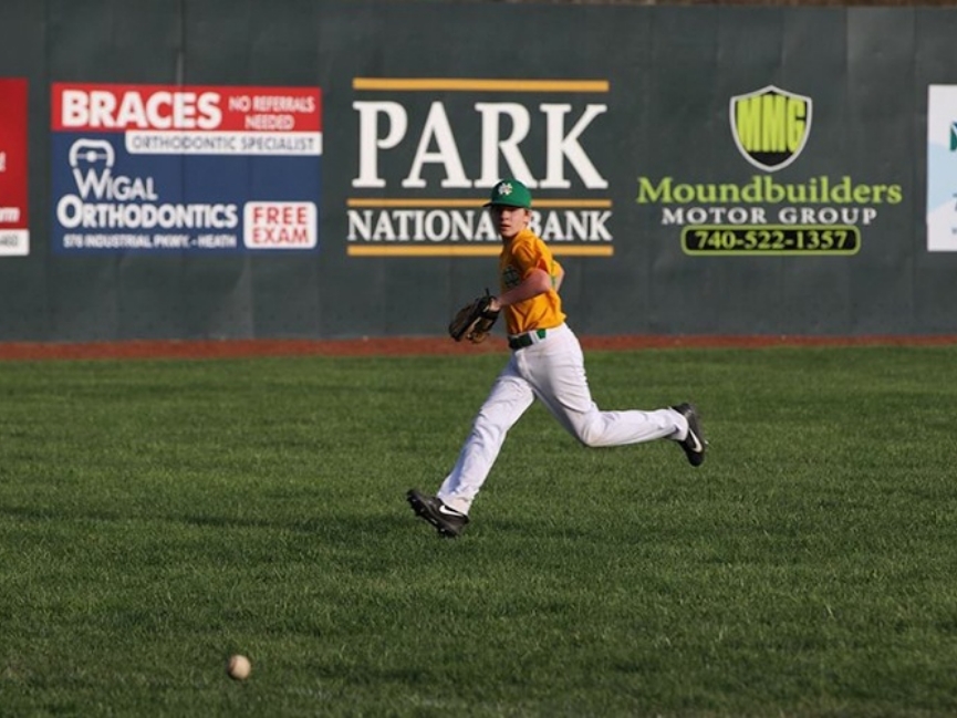 Baseball player rushing to catch baseball