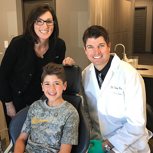 Dr Wigal sitting next to boy in orthodontic chair