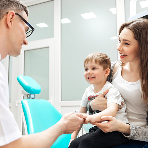 Orthodontist talking to child held by mother