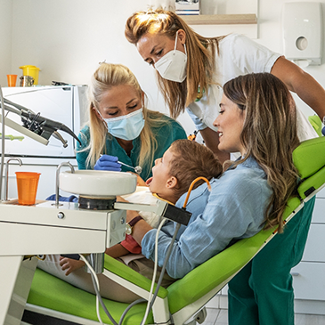 Mother holding child in orthodontic chair