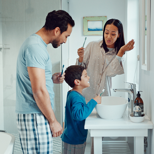 Boy about to brush teeth with mom and dad