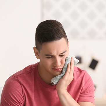 Man holding towel over jaw