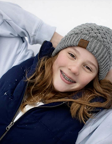 Girl with braces and beanie smiling