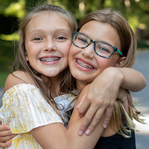 Two girls with braces hugging