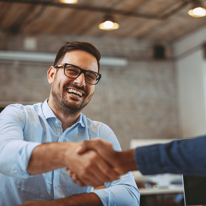 Man with glasses shaking orthodontists hand