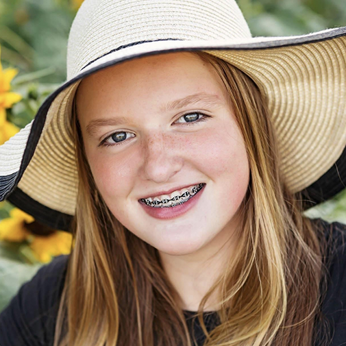 Girl with floppy hat and braces